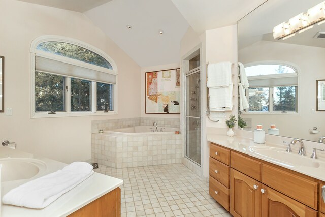 bathroom featuring tile patterned flooring, vanity, vaulted ceiling, and a wealth of natural light