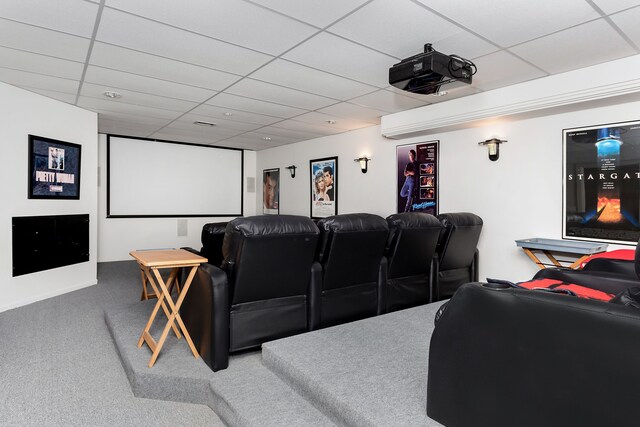 carpeted home theater room with a paneled ceiling