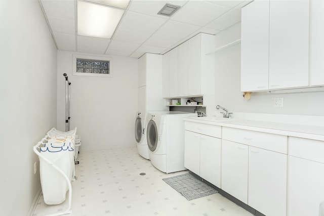 laundry room featuring cabinets, sink, and washing machine and clothes dryer