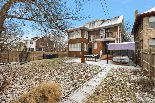 snow covered rear of property featuring a balcony