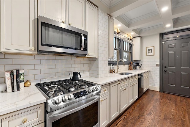 kitchen with light stone counters, beam ceiling, dark hardwood / wood-style flooring, appliances with stainless steel finishes, and sink