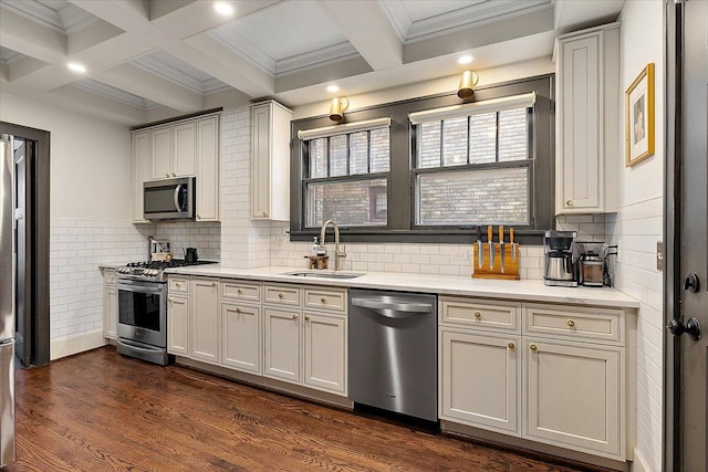 kitchen featuring appliances with stainless steel finishes, beamed ceiling, dark hardwood / wood-style floors, and sink