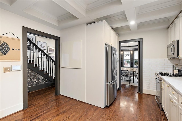 kitchen with stainless steel appliances, white cabinetry, and beamed ceiling