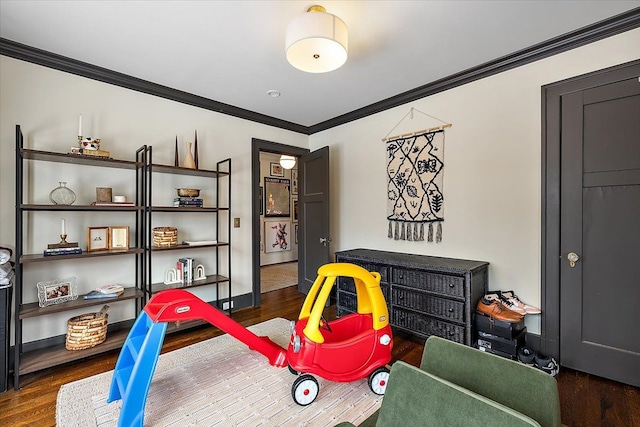 rec room featuring dark wood-type flooring and crown molding