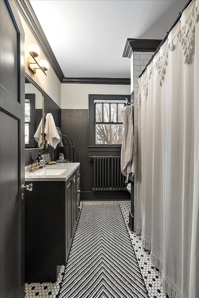 bathroom featuring vanity, crown molding, radiator heating unit, and plenty of natural light