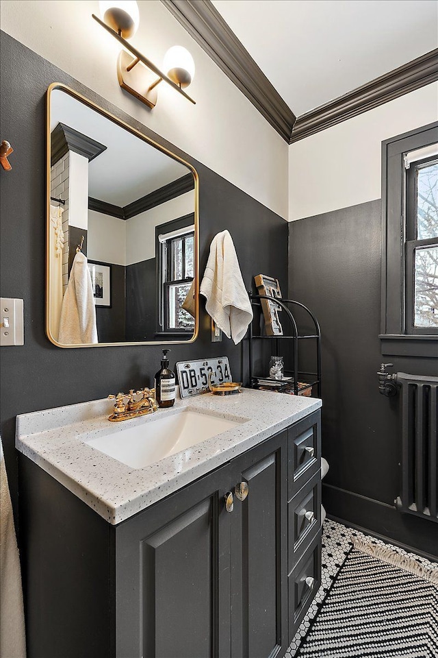 bathroom with tile patterned flooring, vanity, radiator heating unit, and crown molding