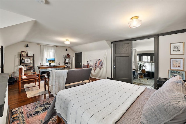 bedroom with lofted ceiling and dark hardwood / wood-style floors