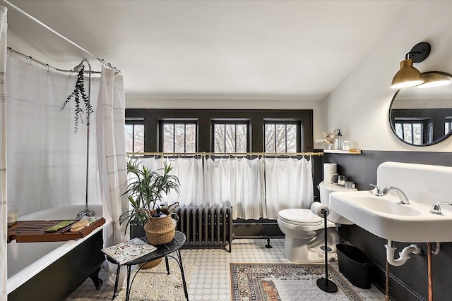 bathroom with toilet, radiator heating unit, and sink