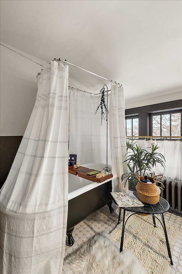 misc room with tile patterned flooring and radiator