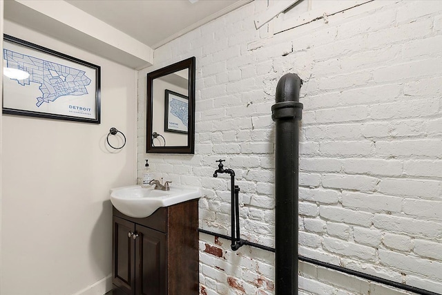 bathroom with brick wall, vanity, and crown molding