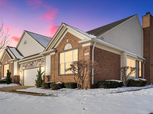 snow covered property featuring a garage