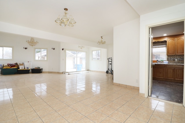 unfurnished living room featuring a notable chandelier and light tile patterned floors