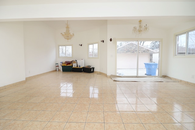 tiled spare room featuring a chandelier