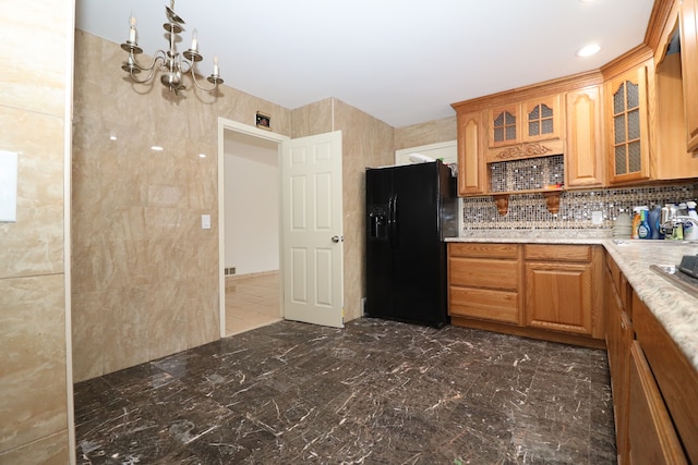 kitchen with a notable chandelier, black fridge, and tasteful backsplash