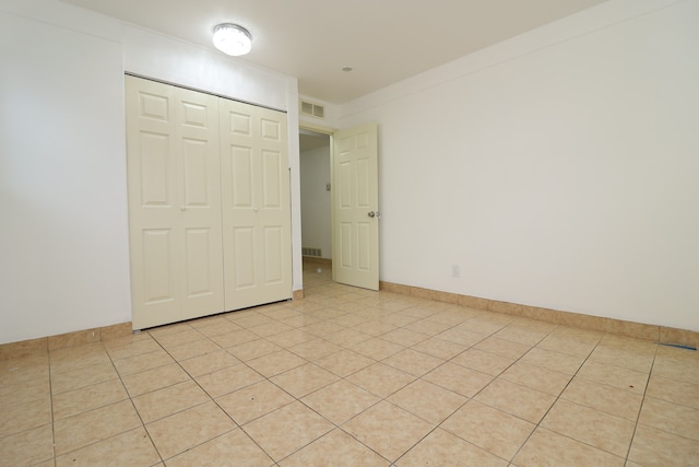 unfurnished bedroom featuring light tile patterned floors and a closet