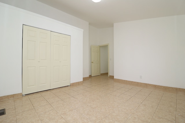 unfurnished bedroom featuring a closet and light tile patterned flooring