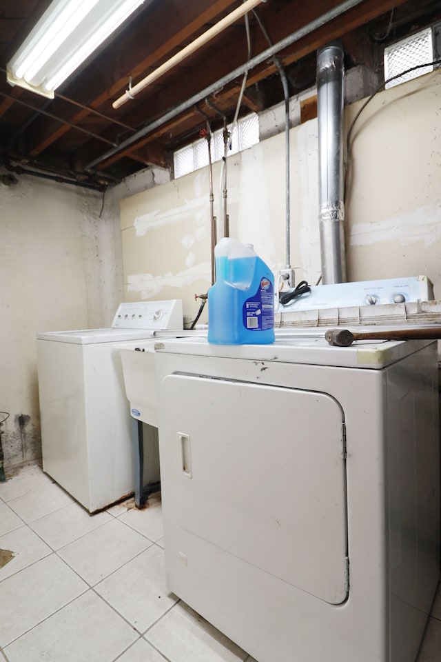 laundry room with light tile patterned floors and washing machine and clothes dryer