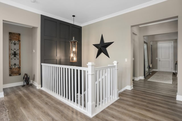 hallway featuring hardwood / wood-style floors, an inviting chandelier, and ornamental molding