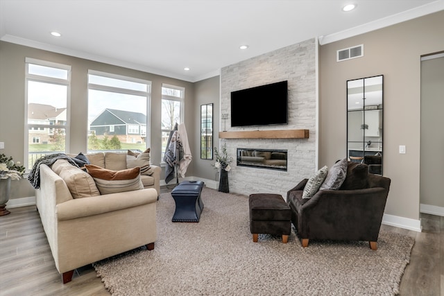 living room featuring crown molding, a fireplace, and hardwood / wood-style flooring