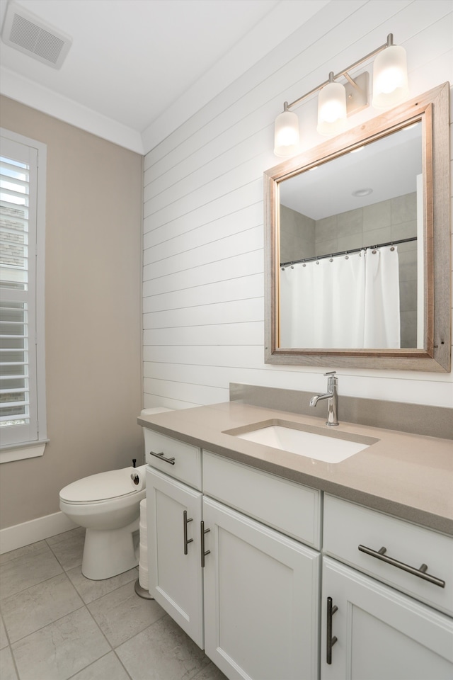 bathroom featuring tile patterned flooring, vanity, toilet, and crown molding