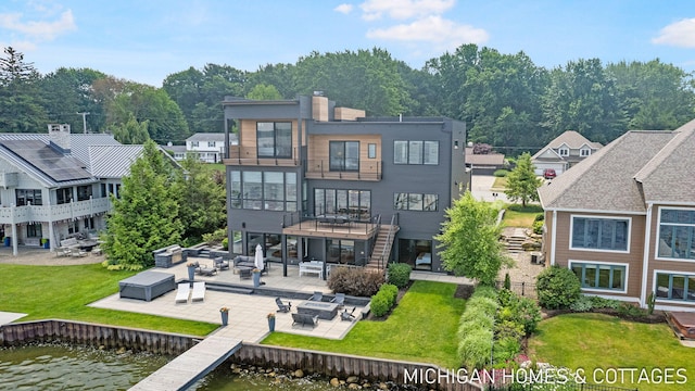 rear view of house featuring a patio area, a balcony, and a water view