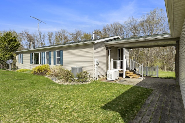 view of side of property featuring central AC and a lawn
