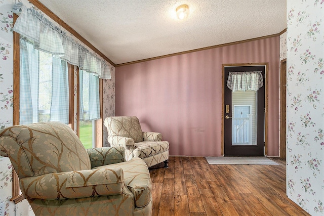 living area featuring crown molding, hardwood / wood-style floors, and a textured ceiling