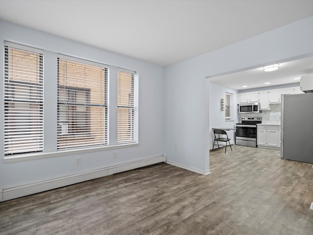 interior space with plenty of natural light, light hardwood / wood-style floors, and a baseboard radiator