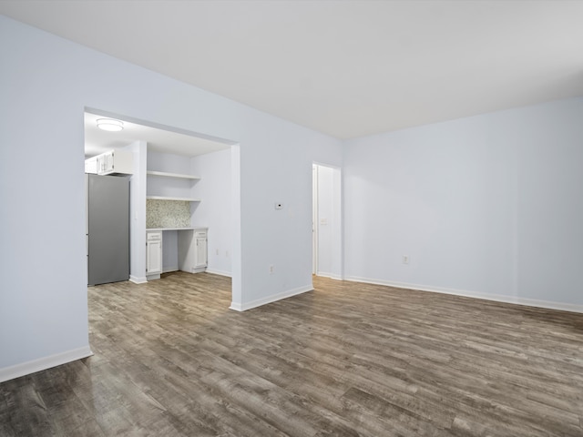 empty room with built in desk and hardwood / wood-style flooring