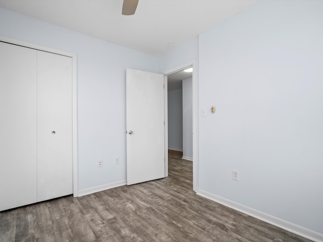 unfurnished bedroom with hardwood / wood-style flooring, ceiling fan, and a closet