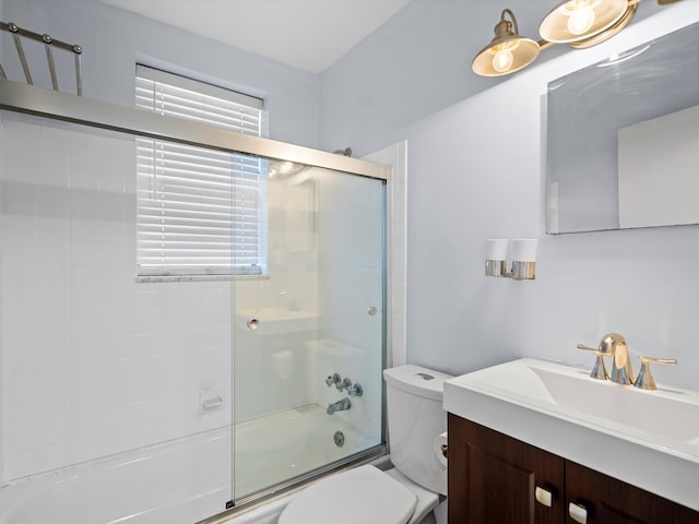 full bathroom with vanity, enclosed tub / shower combo, and toilet