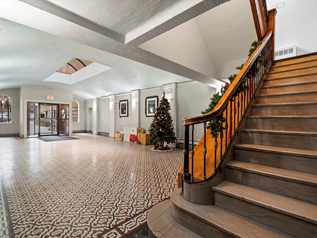 interior space with a textured ceiling and vaulted ceiling