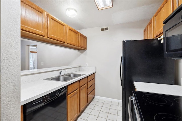 kitchen featuring sink, light tile patterned floors, and black appliances