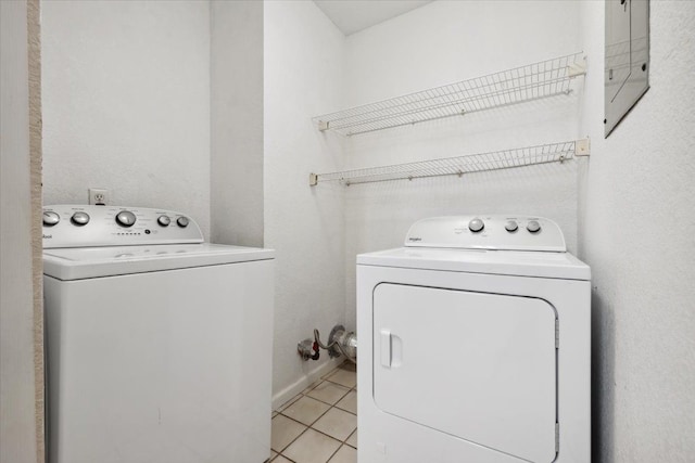 laundry room with independent washer and dryer and light tile patterned floors