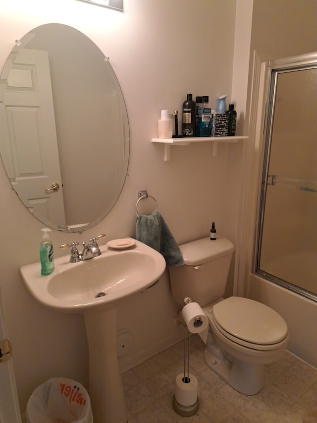 bathroom with shower / bath combination with glass door, tile patterned flooring, and toilet