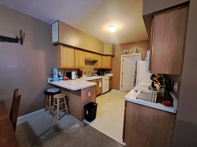 kitchen featuring dishwasher, kitchen peninsula, a breakfast bar area, and sink