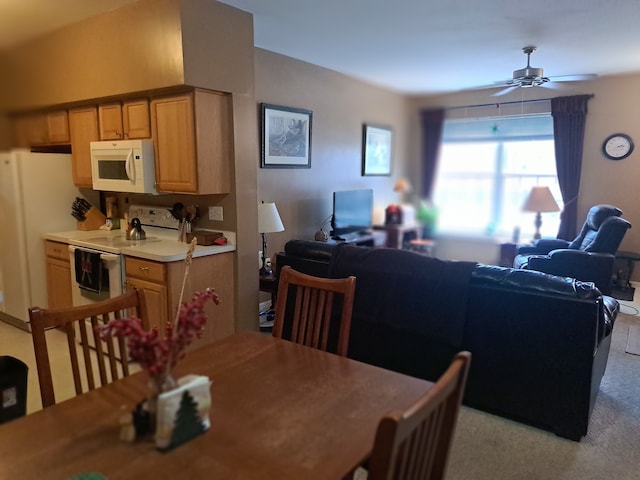 carpeted dining room featuring ceiling fan