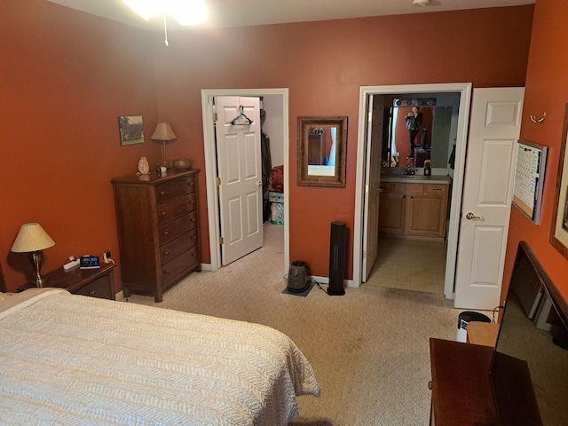 bedroom with light carpet and connected bathroom