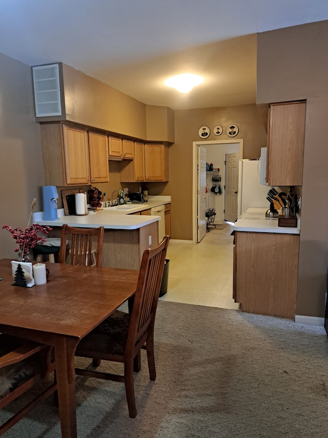 dining space with light colored carpet and sink