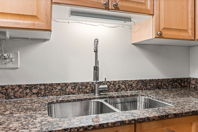 details featuring dark stone countertops and sink