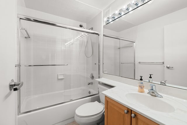 full bathroom with vanity, enclosed tub / shower combo, and toilet