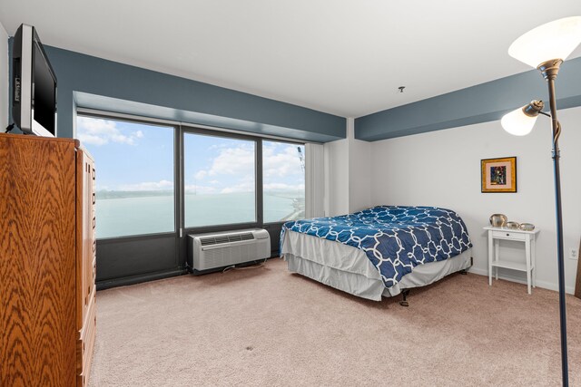 bedroom featuring an AC wall unit, carpet floors, and a water view