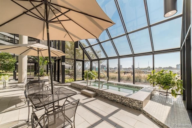 view of patio / terrace featuring glass enclosure and an in ground hot tub