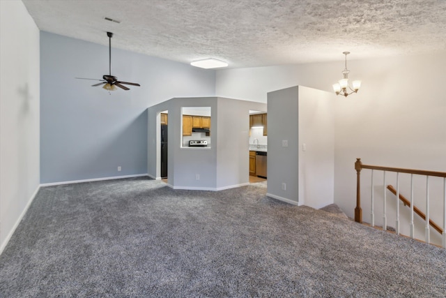 unfurnished living room with dark carpet, a textured ceiling, ceiling fan with notable chandelier, vaulted ceiling, and sink