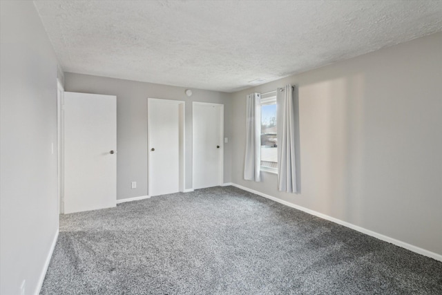 unfurnished room with a textured ceiling and carpet floors