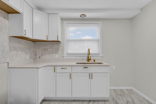 kitchen featuring white cabinets, tasteful backsplash, and sink