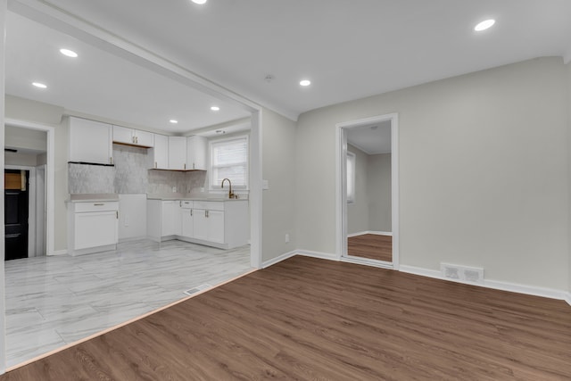 unfurnished living room featuring light hardwood / wood-style floors and sink