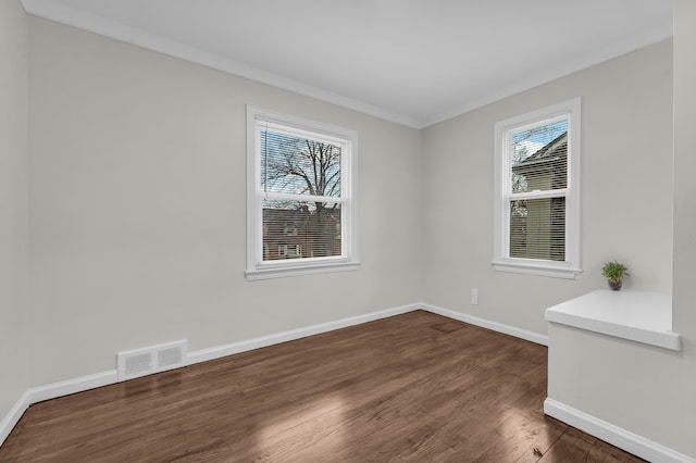 spare room with ornamental molding, dark hardwood / wood-style floors, and a healthy amount of sunlight