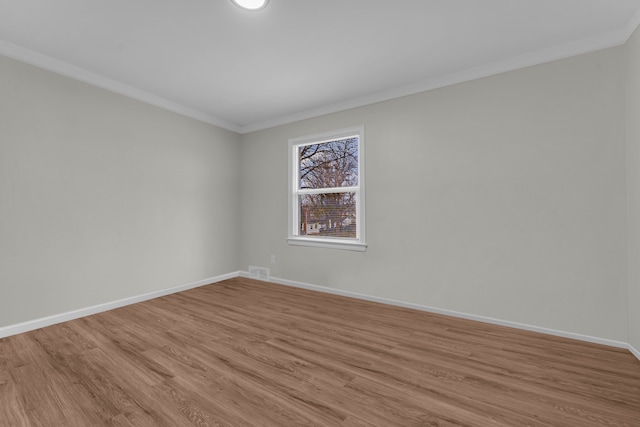 unfurnished room featuring light wood-type flooring and ornamental molding