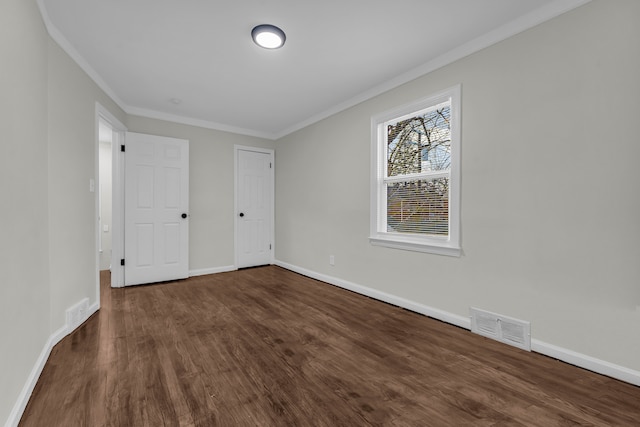 unfurnished bedroom featuring crown molding and dark wood-type flooring